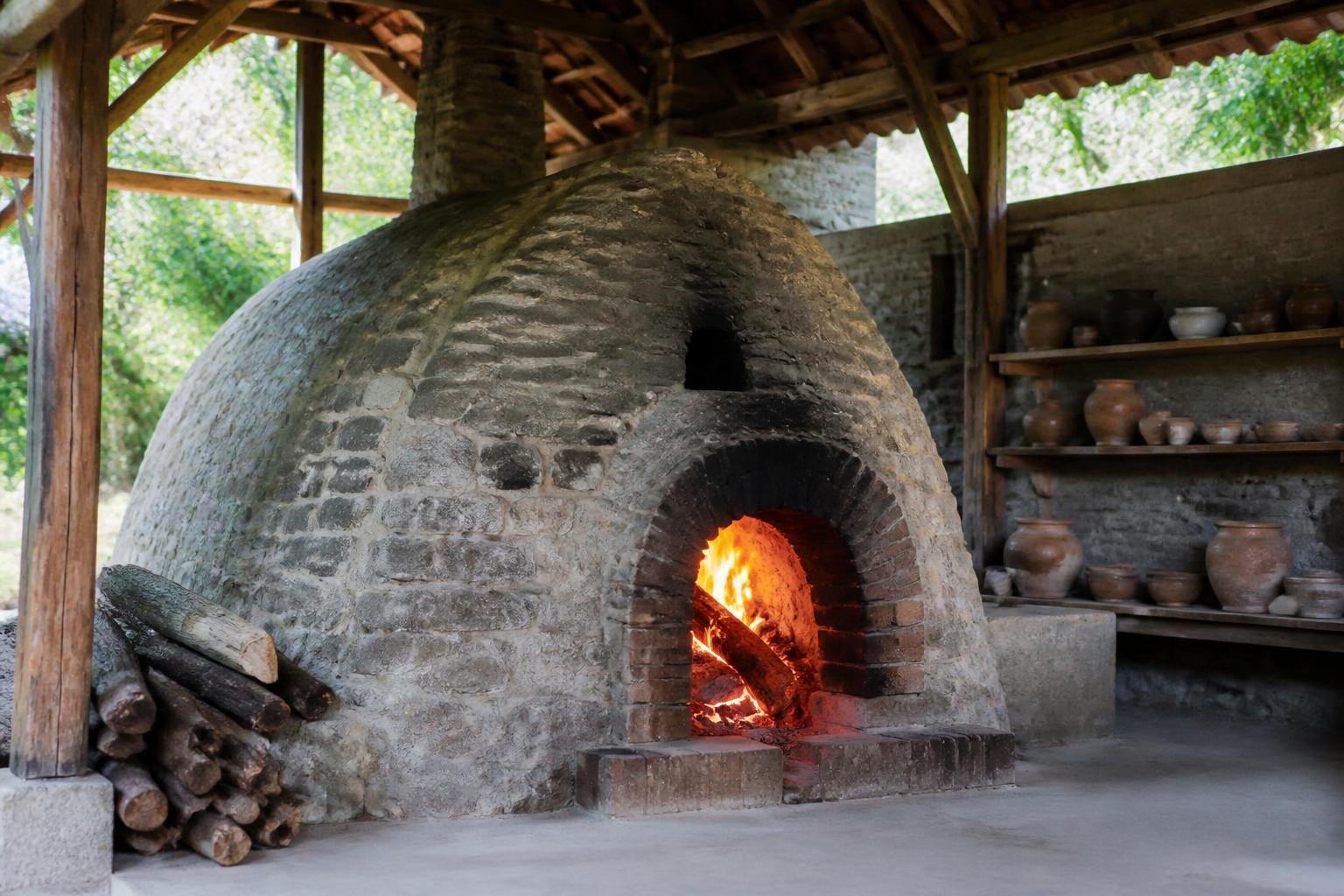 Four à bois traditionnel avec flammes visibles, utilisé pour la cuisson de céramiques